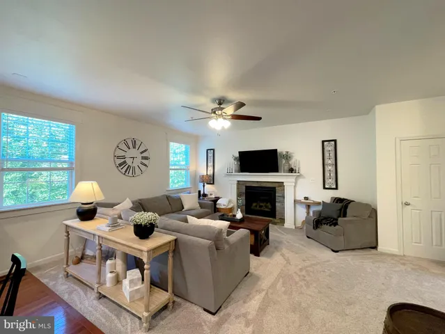 a living room with furniture and a ceiling fan