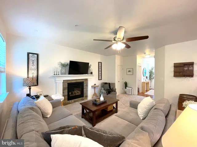 a living room with furniture a fireplace and a flat screen tv