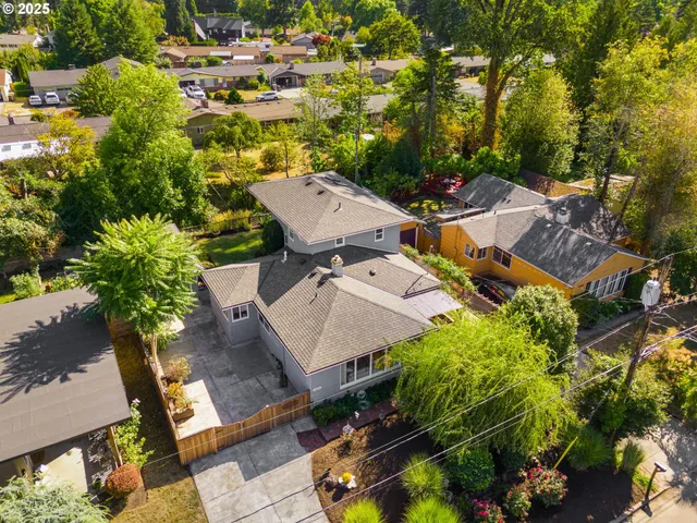 an aerial view of residential house with outdoor space and trees all around