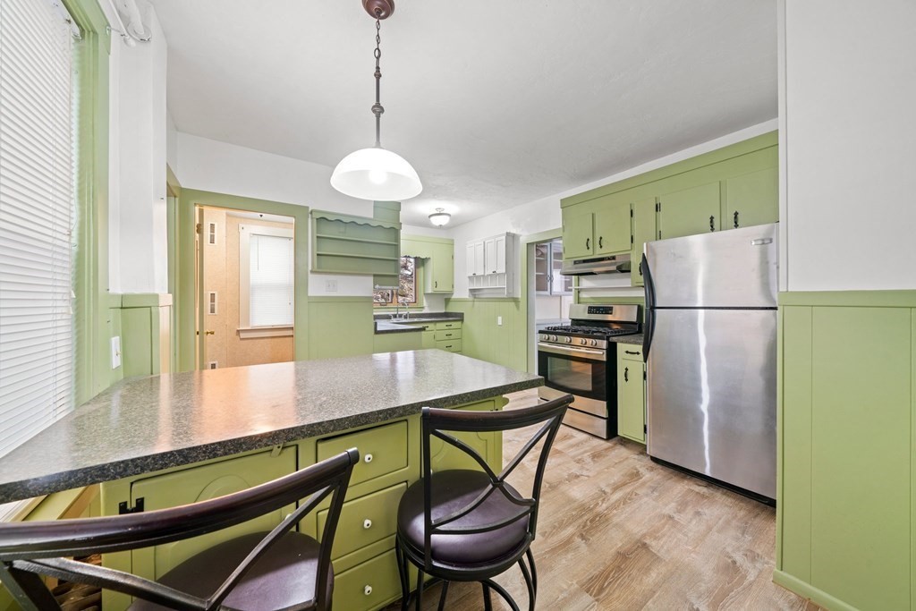 44 Beaconsfield Road Worcester, MA 01602 - Photo 8 of 32 a kitchen with stainless steel appliances granite countertop a refrigerator a stove a sink dishwasher a dining table and chairs with wooden floor