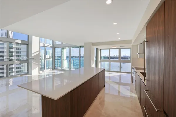 a large white kitchen with a large window