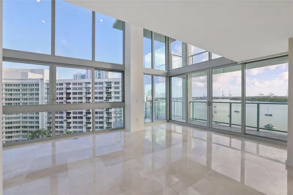 a living room with stainless steel appliances kitchen island granite countertop a refrigerator and a sink