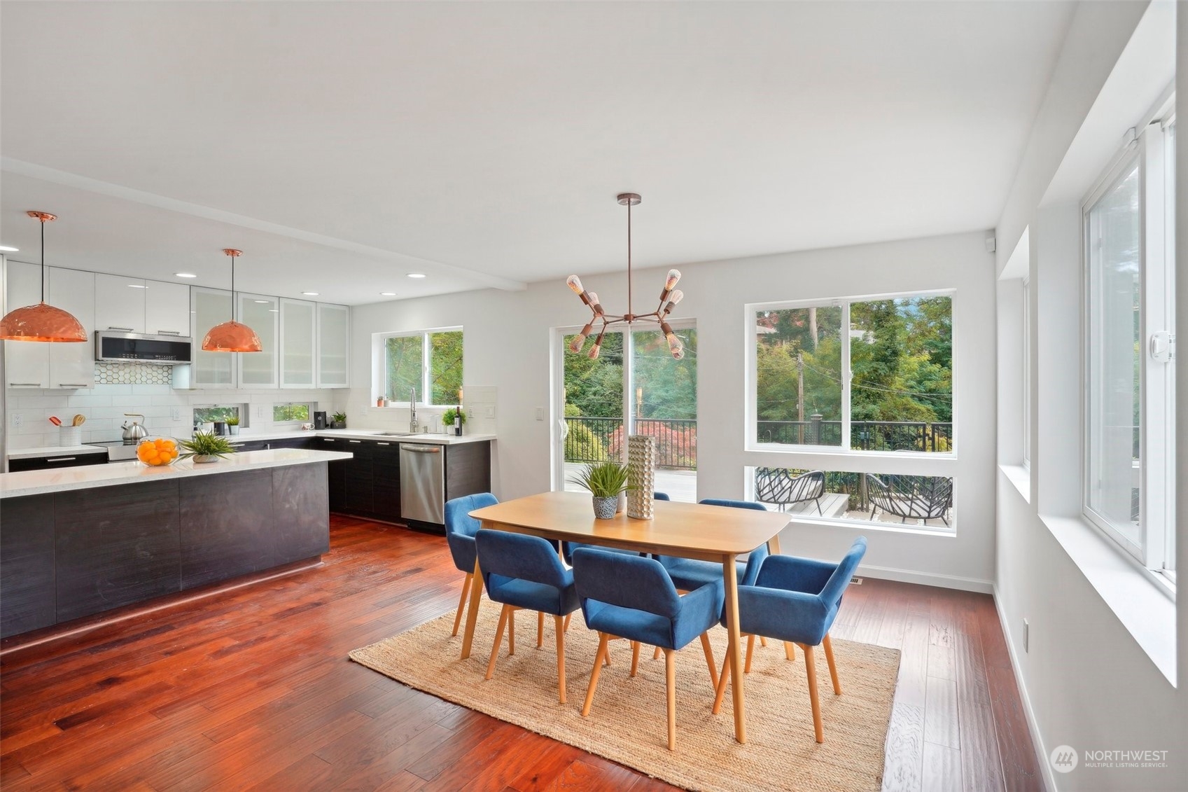 7453 Gatewood Road Southwest Seattle, WA 98136 - Photo 7 of 40 a kitchen with stainless steel appliances wooden floor dining table and chairs