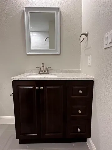 a bathroom with a sink vanity and mirror