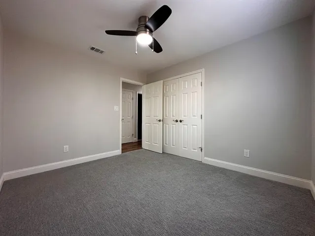 an empty room with chandelier fan