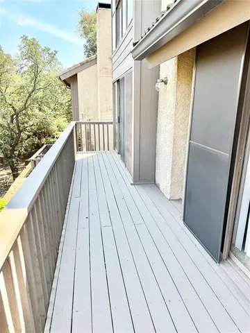 a view of a balcony with wooden floor and fence