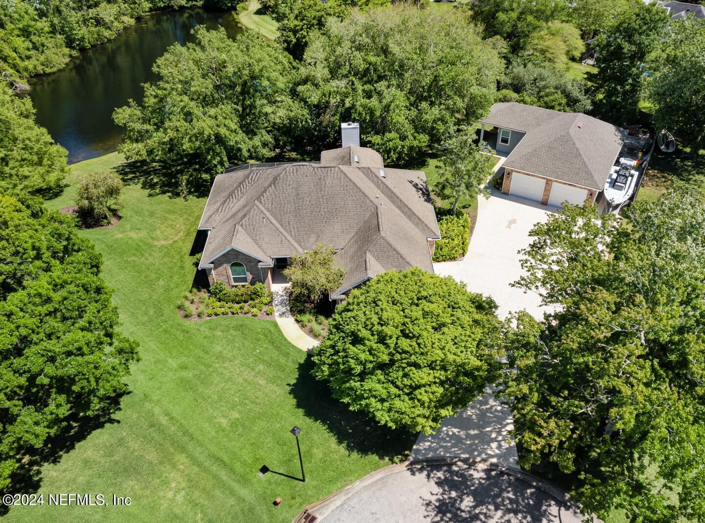 an aerial view of a house with yard and green space