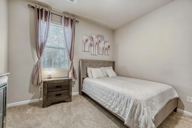 a bedroom with a bed dresser and a window