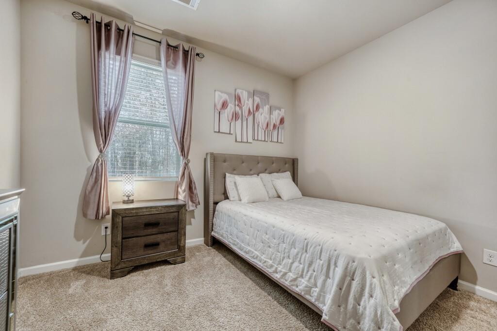 1526 Woodvale Street Hampton, GA 30228 - Photo 15 of 31 a bedroom with a bed dresser and a window