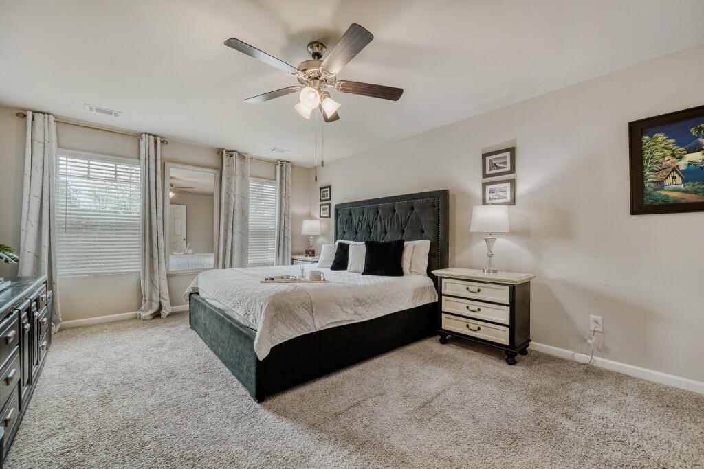 1526 Woodvale Street Hampton, GA 30228 - Photo 18 of 31 a spacious bedroom with a bed and a chandelier