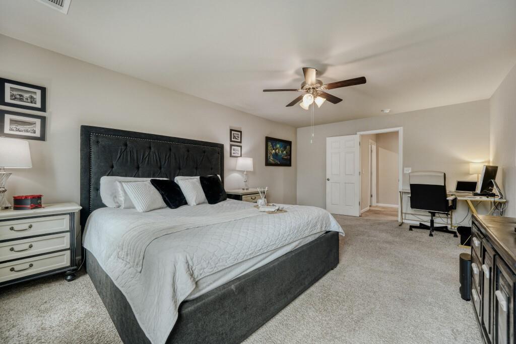 1526 Woodvale Street Hampton, GA 30228 - Photo 19 of 31 a spacious bedroom with a bed and a ceiling fan