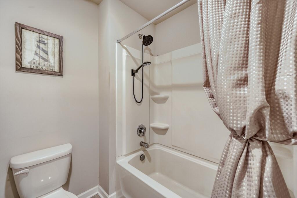1526 Woodvale Street Hampton, GA 30228 - Photo 26 of 31 a bathroom with a bathtub a toilet and a shower