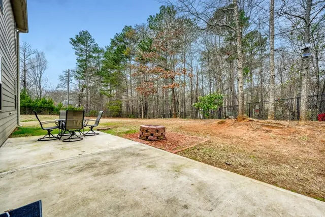 a view of backyard with a bench and trees
