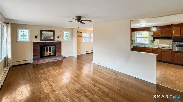 an empty room with a fireplace and wooden floor