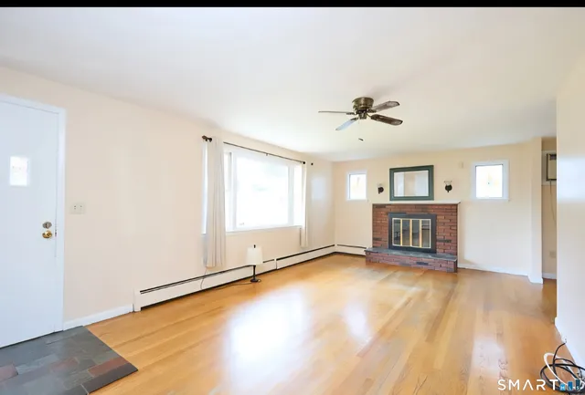 an empty room with windows and ceiling fan