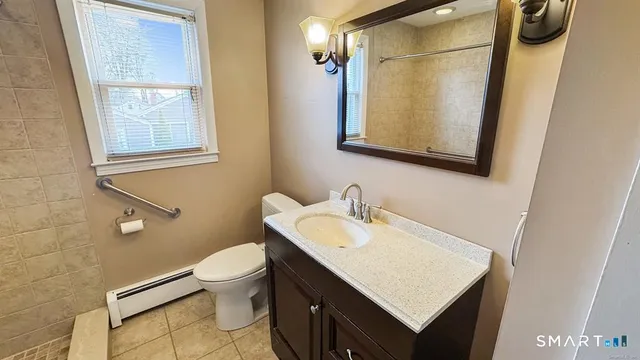 a bathroom with a sink vanity mirror and toilet