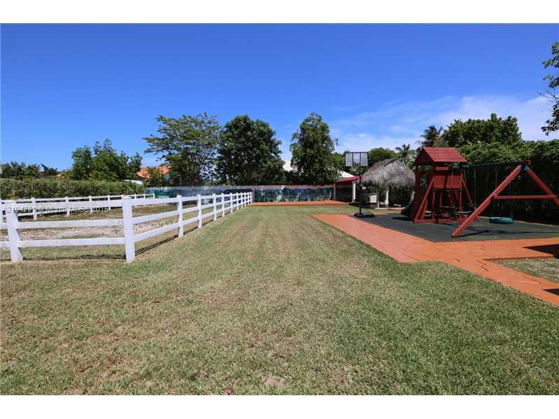 3845 Southwest 128th Avenue Miami, FL 33175 - Photo 30 of 35 a view of a swimming pool with lawn chairs and a dining table under an umbrella