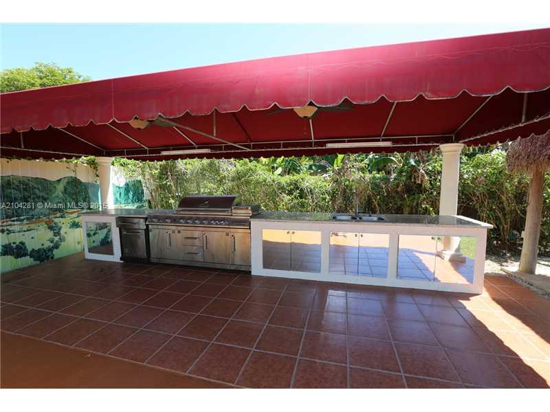 3845 Southwest 128th Avenue Miami, FL 33175 - Photo 32 of 35 a view of a swimming pool with a table and chairs under an umbrella