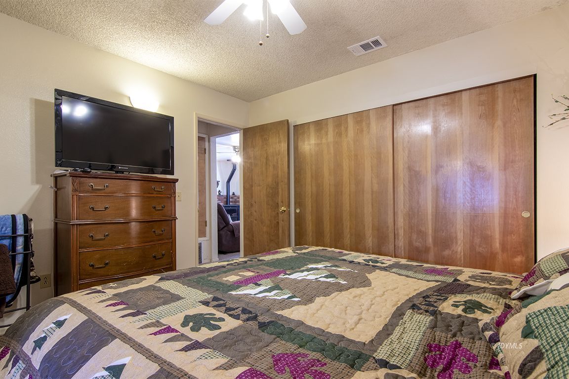 26833 Idyllwild Road Idyllwild, CA 92549 - Photo 28 of 38 a bedroom with a bed and a flat screen tv
