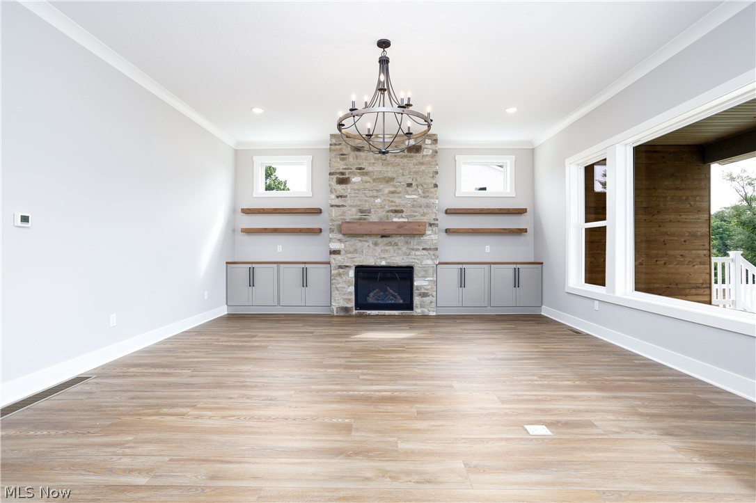 5796 Springlake Road Northwest Canton, OH 44718 - Photo 14 of 50 Unfurnished living room with a healthy amount of sunlight, a fireplace, and light luxury plank flooring