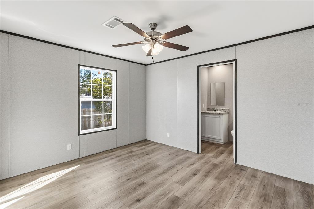 2003 Oak Street St. Cloud, FL 34769 - Photo 14 of 20 an empty room with wooden floor fan and windows