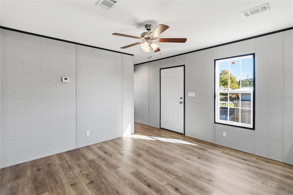 2003 Oak Street St. Cloud, FL 34769 - Photo 8 of 20 an empty room with wooden floor closet and windows