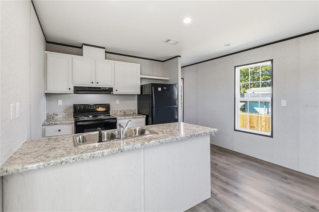 2003 Oak Street St. Cloud, FL 34769 - Photo 10 of 20 a kitchen with stainless steel appliances granite countertop a sink stove and cabinets