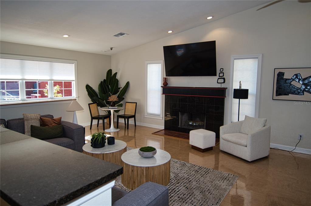 1793 Hampton Lane, Unit 110 Palm Harbor, FL 34683 - Photo 33 of 35 a living room with furniture a flat screen tv and a fireplace