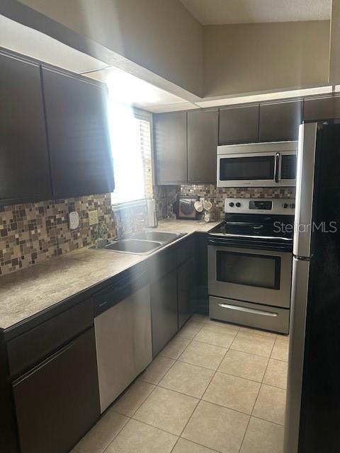 1793 Hampton Lane, Unit 110 Palm Harbor, FL 34683 - Photo 5 of 35 a kitchen with stainless steel appliances a stove sink and refrigerator