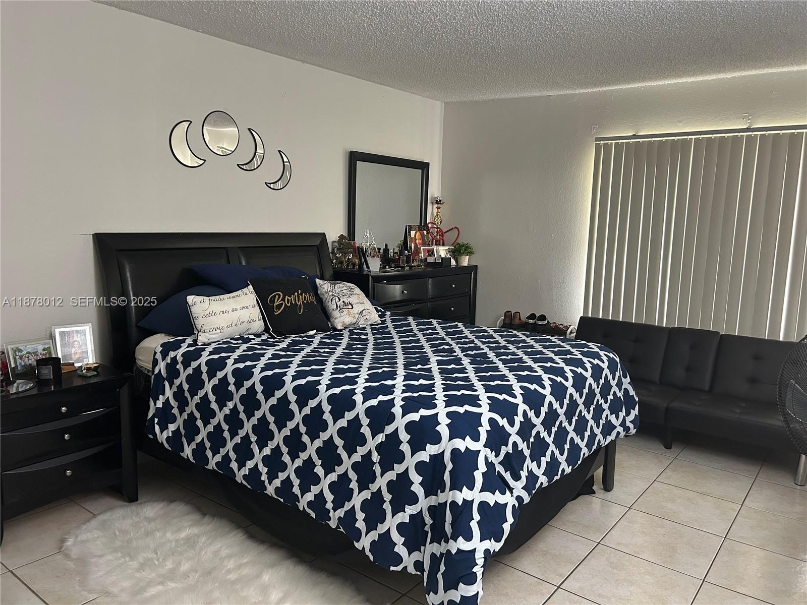 17901 Northwest 68th Avenue, Unit T101 Hialeah, FL 33015 - Photo 14 of 45 a bedroom with a bed and a night stand