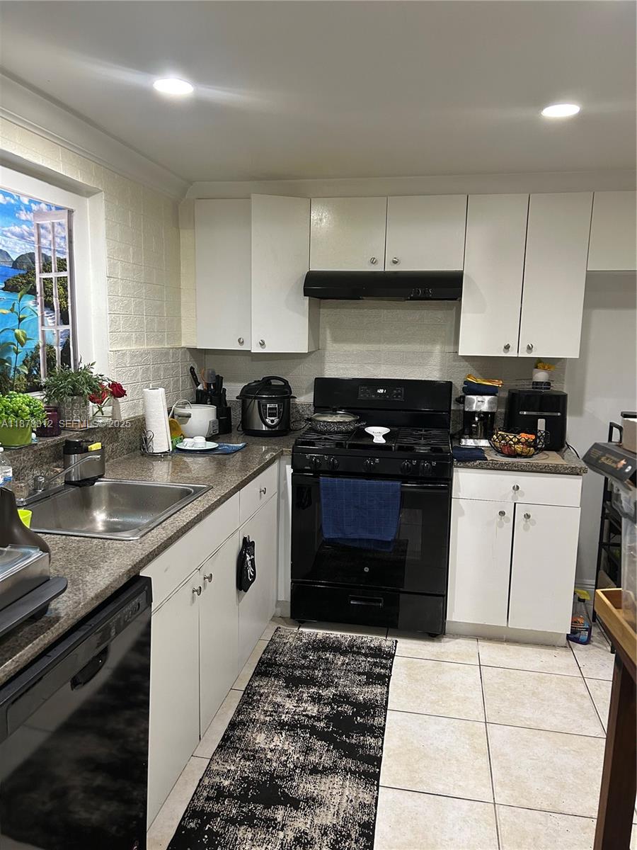 17901 Northwest 68th Avenue, Unit T101 Hialeah, FL 33015 - Photo 19 of 45 a kitchen with a sink a stove and cabinets