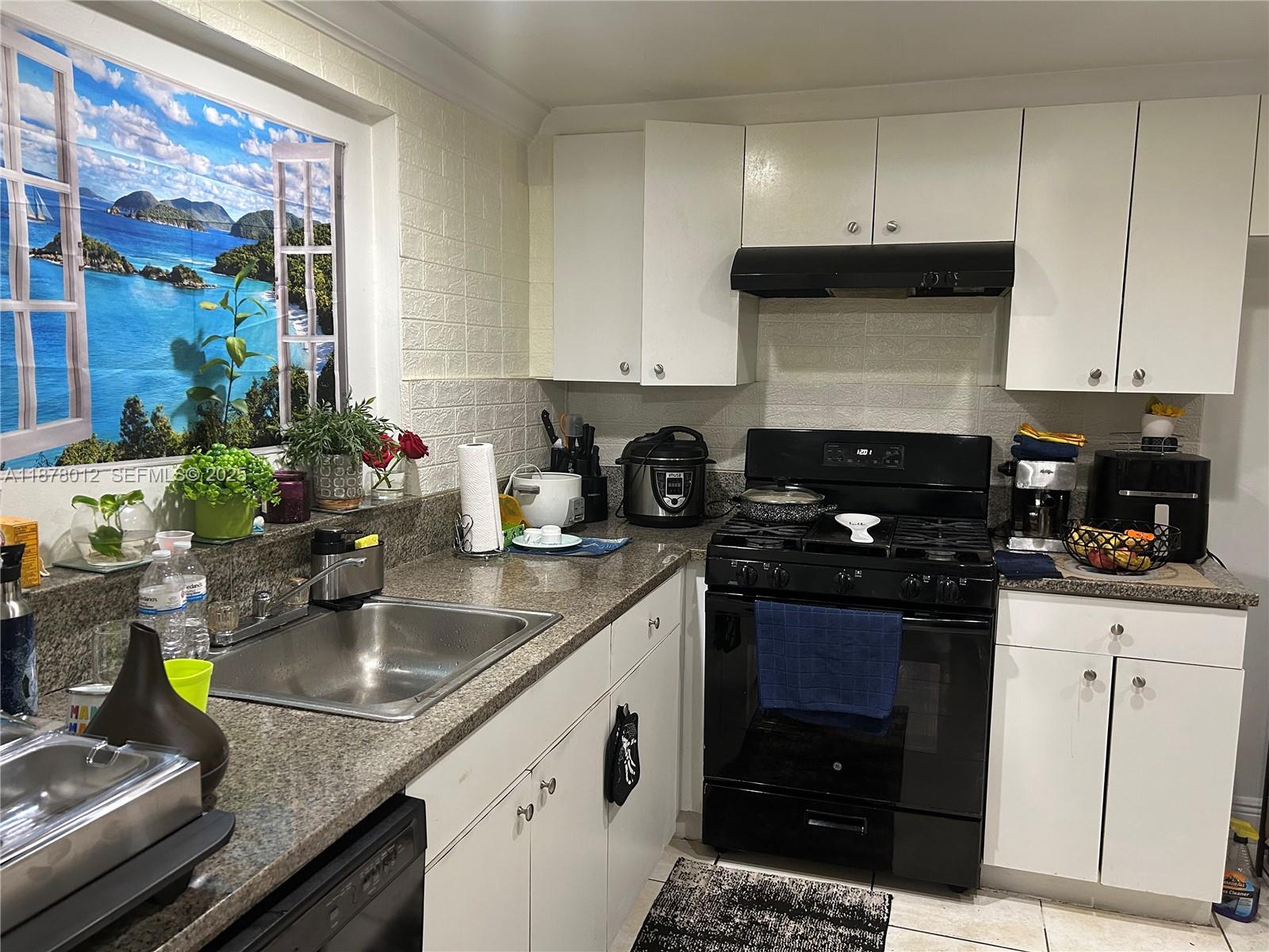 17901 Northwest 68th Avenue, Unit T101 Hialeah, FL 33015 - Photo 20 of 45 a kitchen with a sink a stove and cabinets