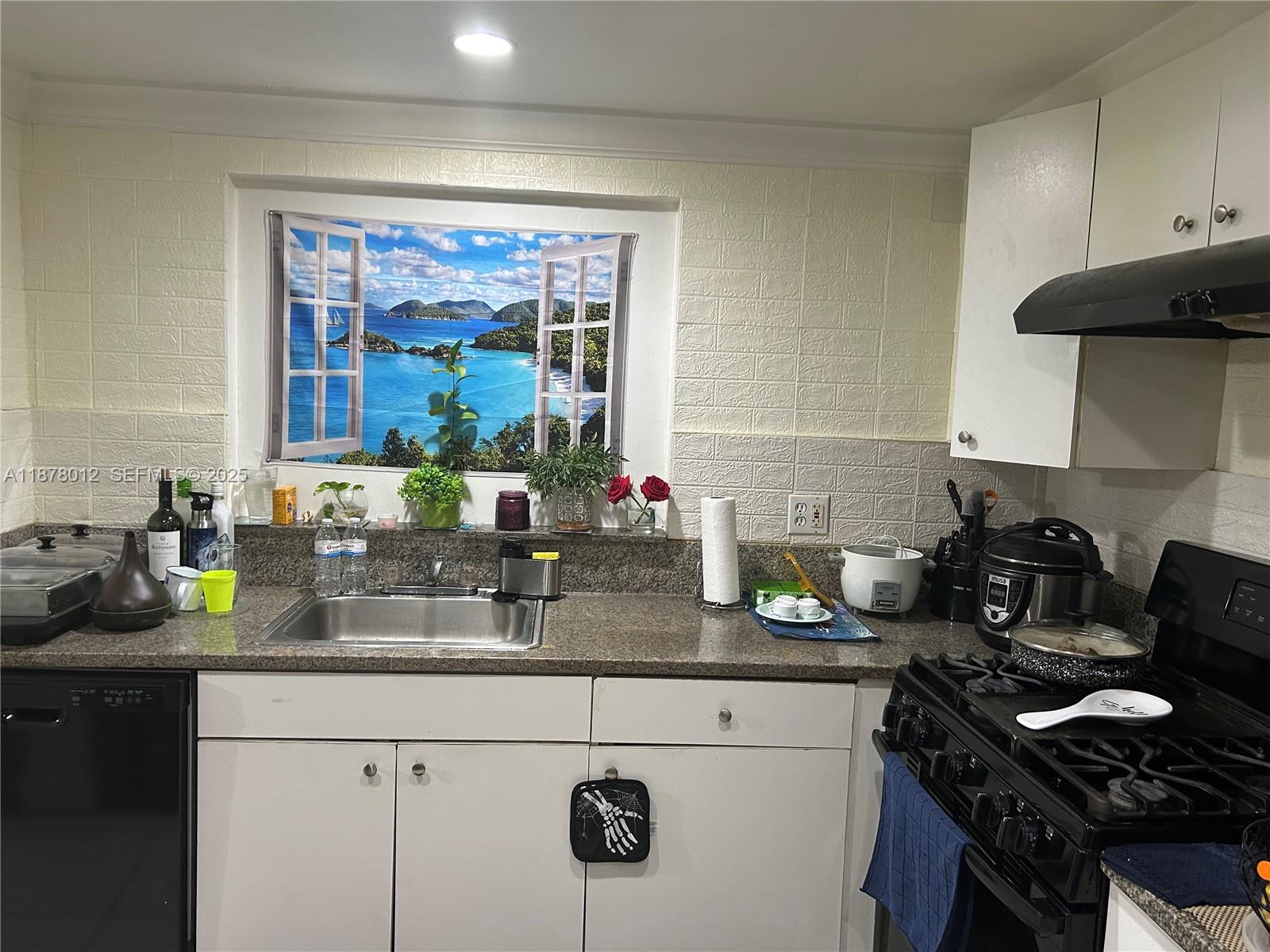 17901 Northwest 68th Avenue, Unit T101 Hialeah, FL 33015 - Photo 22 of 45 a kitchen with a sink stove and cabinets