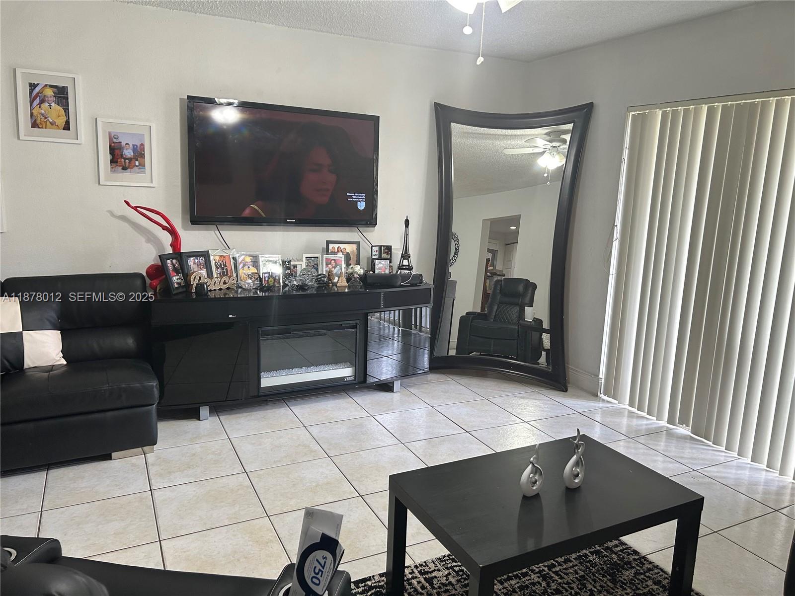 17901 Northwest 68th Avenue, Unit T101 Hialeah, FL 33015 - Photo 4 of 45 a living room with furniture and a flat screen tv