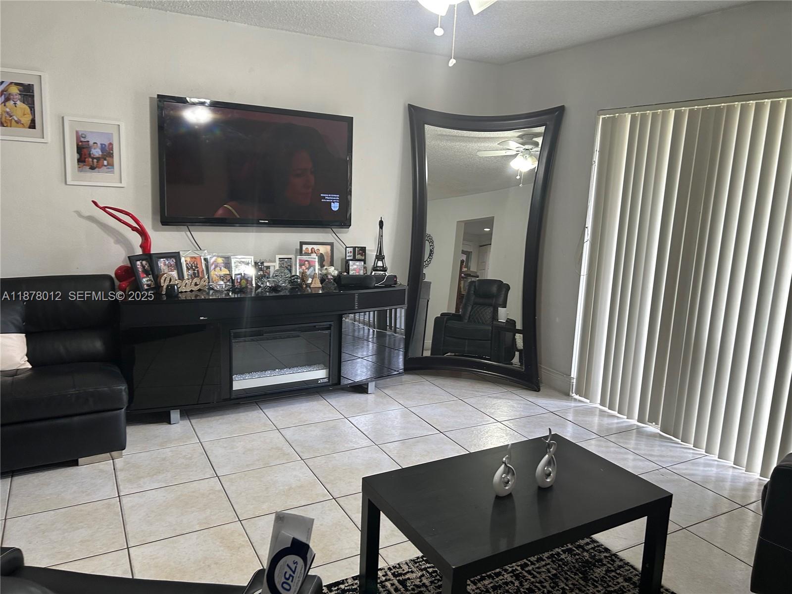 17901 Northwest 68th Avenue, Unit T101 Hialeah, FL 33015 - Photo 5 of 45 a living room with furniture and a flat screen tv
