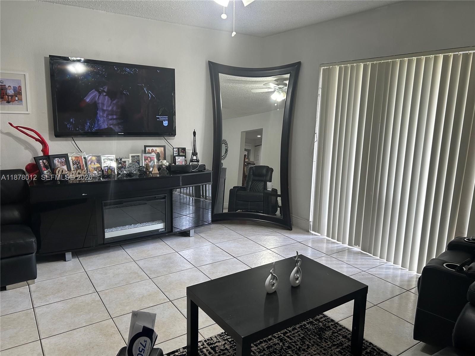 17901 Northwest 68th Avenue, Unit T101 Hialeah, FL 33015 - Photo 6 of 45 a living room with furniture and a flat screen tv