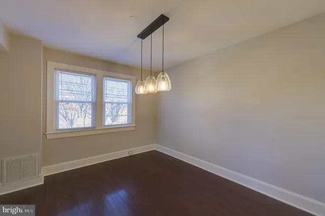 a view of a room with wooden floor chandelier and windows
