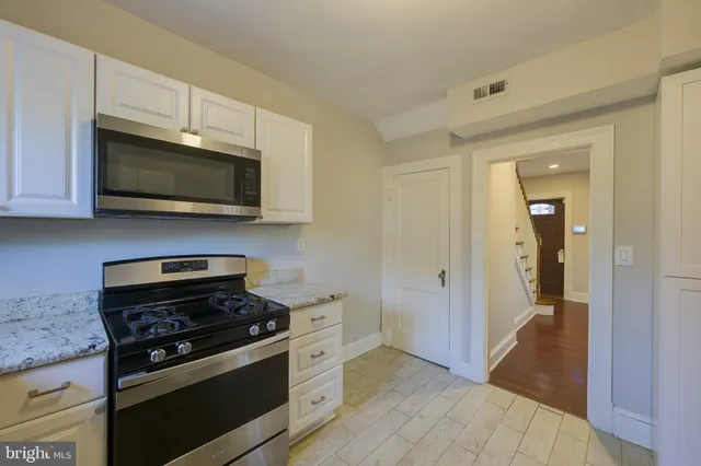 a kitchen with granite countertop a stove and a microwave