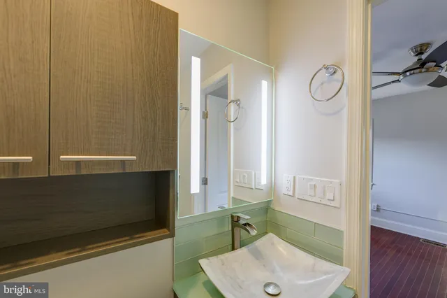 a bathroom with a sink a toilet and a mirror