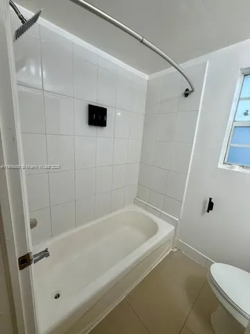 a white bath tub sitting next to a toilet