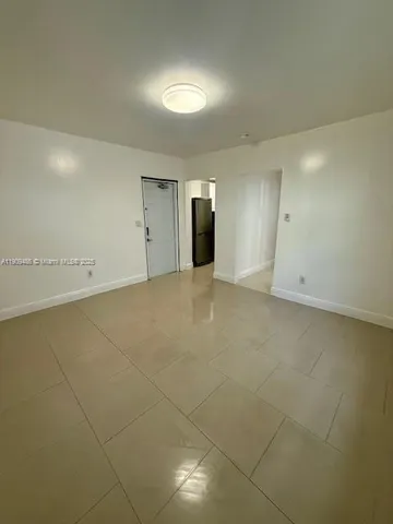 an empty room with an entryway and fan