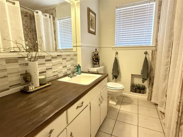 a bathroom with a granite countertop sink toilet and mirror