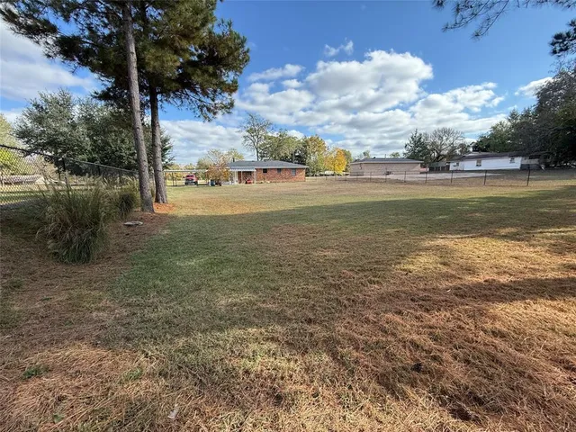 a view of a field with some trees in the background