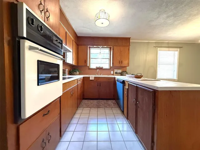 a large kitchen with stainless steel appliances granite countertop a sink counter space cabinets and a window