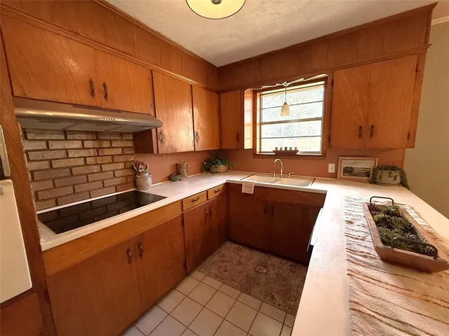 a kitchen with stainless steel appliances granite countertop a sink stove and cabinets
