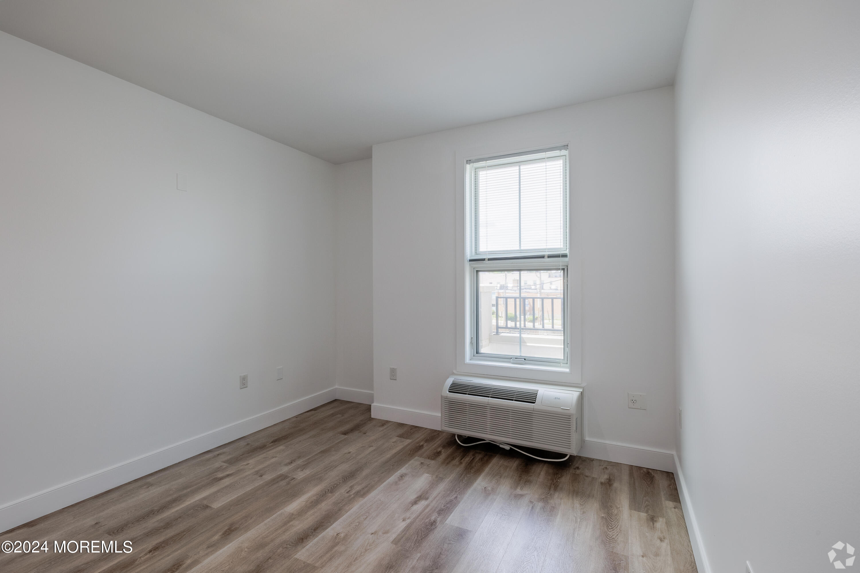 126 Main Street, Unit 410 Matawan, NJ 07747 - Photo 6 of 13 an empty room with wooden floor and windows