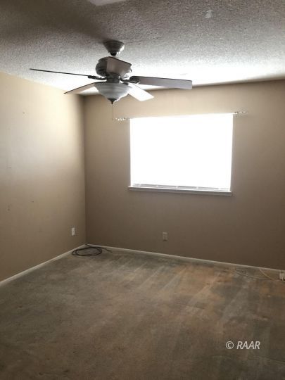 1219 North Erwin Street Ridgecrest, CA 93555 - Photo 7 of 20 an empty room with a fan and a window