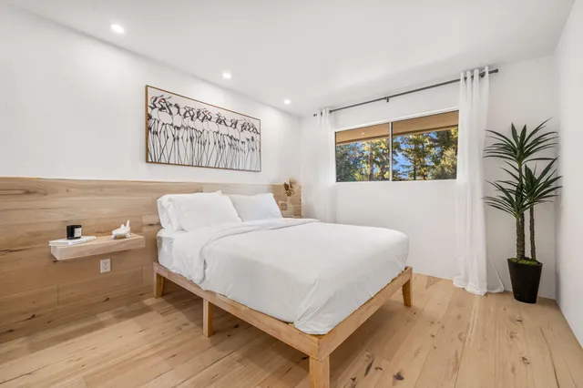 a bedroom with a bed and a potted plant