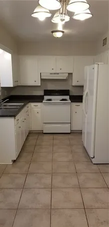 a kitchen with a stove cabinets and a refrigerator
