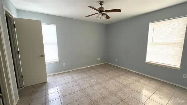 an empty room with a window and a fan